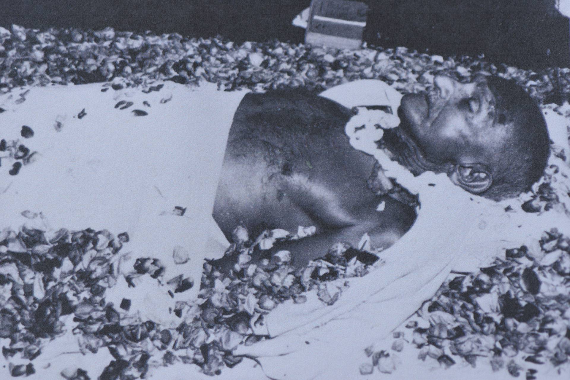 Photo 1. Body Ghandi covered with flowers